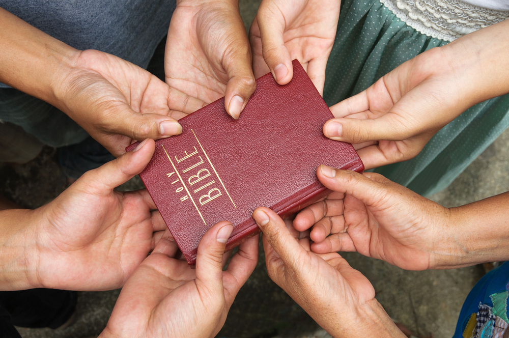 Group,of,people,holding,holy,bible,and,praying.